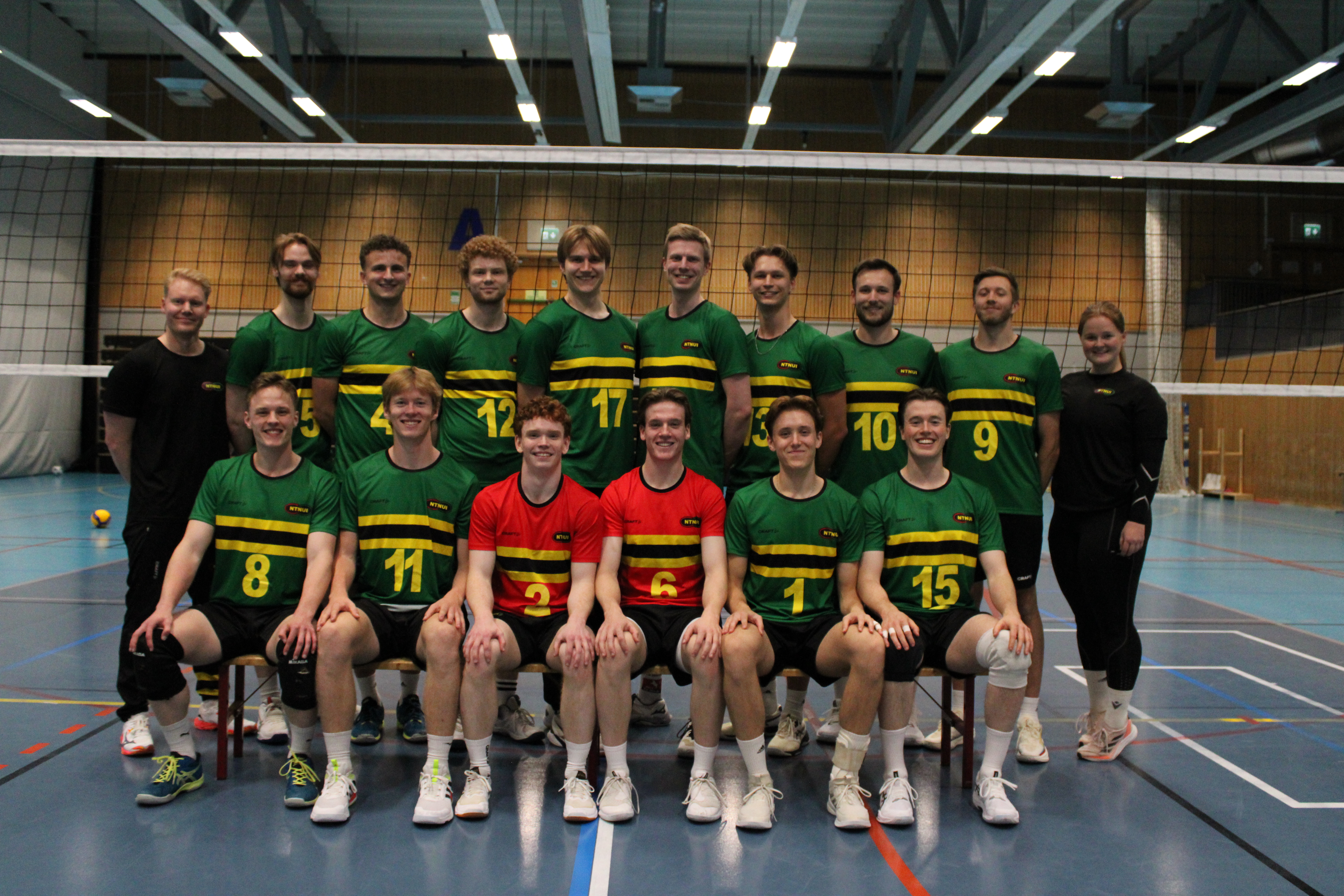 Lagbilde av NTNUI H-elite samlet foran volleyballnettet