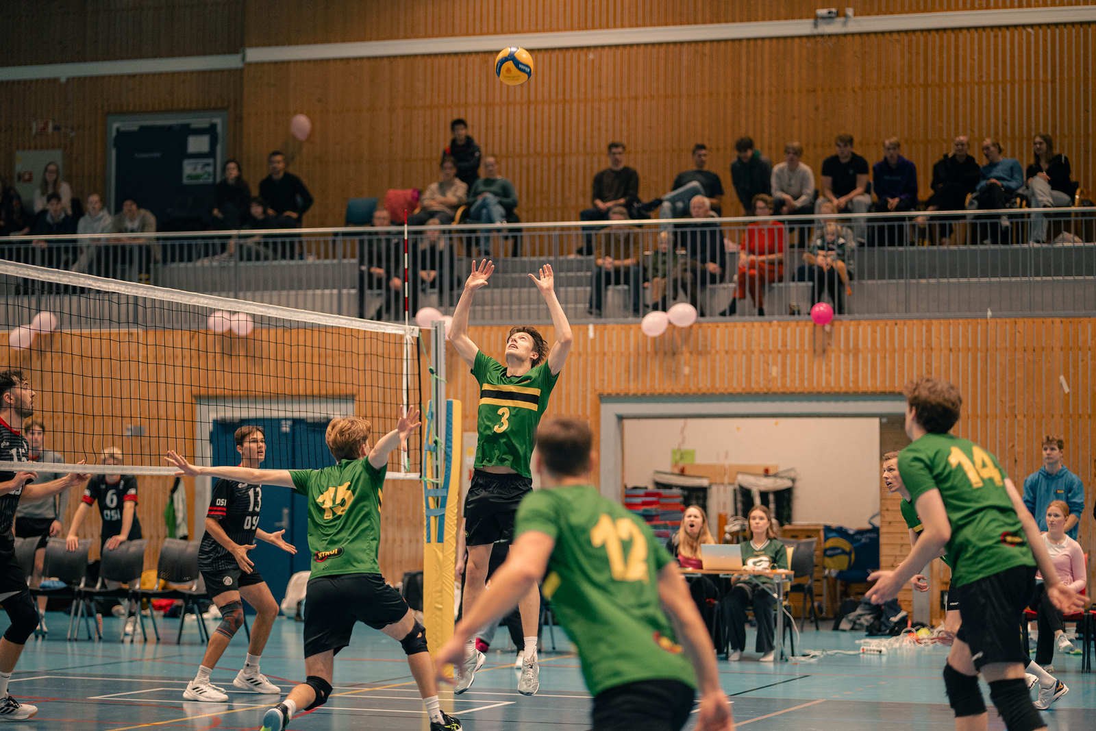 NTNUI-spillere i angrep ved nettet under en volleyballkamp