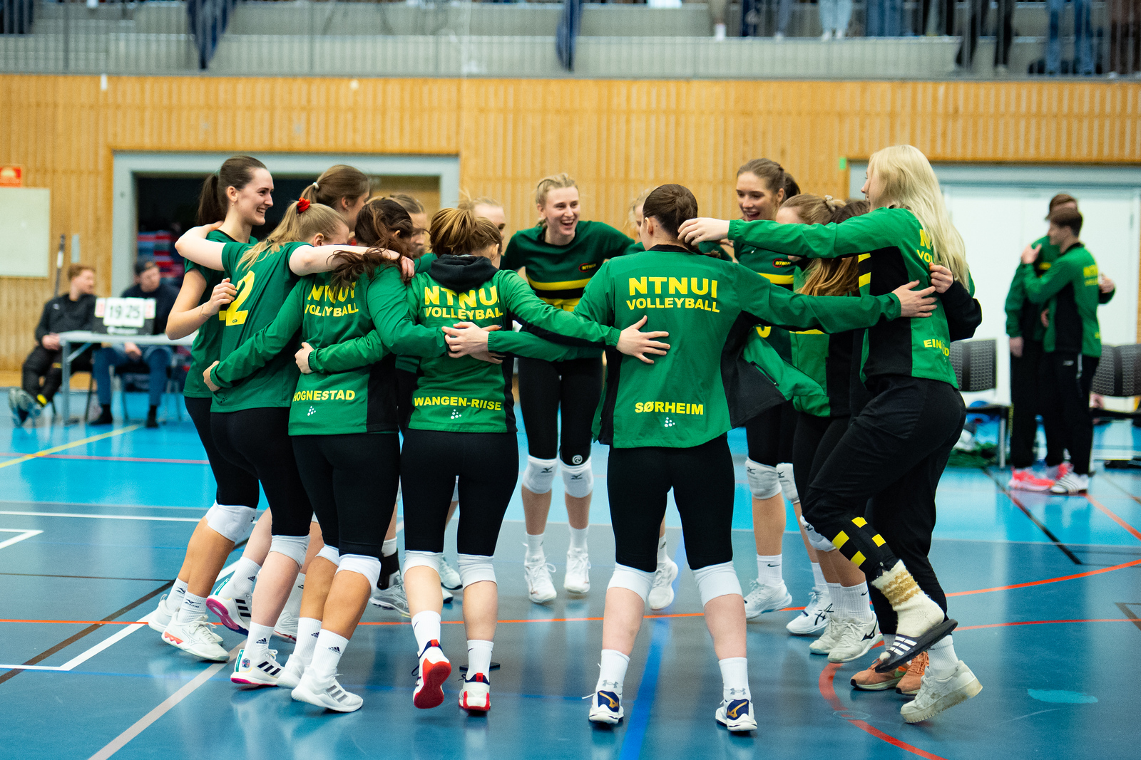 NTNUI sitt damelag samlet i en sirkel på volleyballbanen